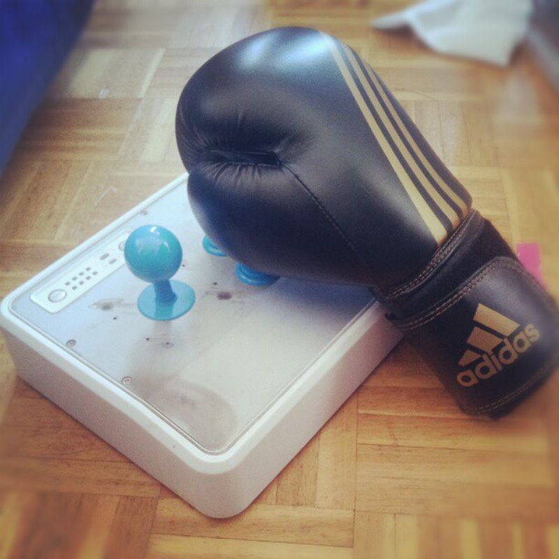 A boxing glove on an arcade stick figcaption